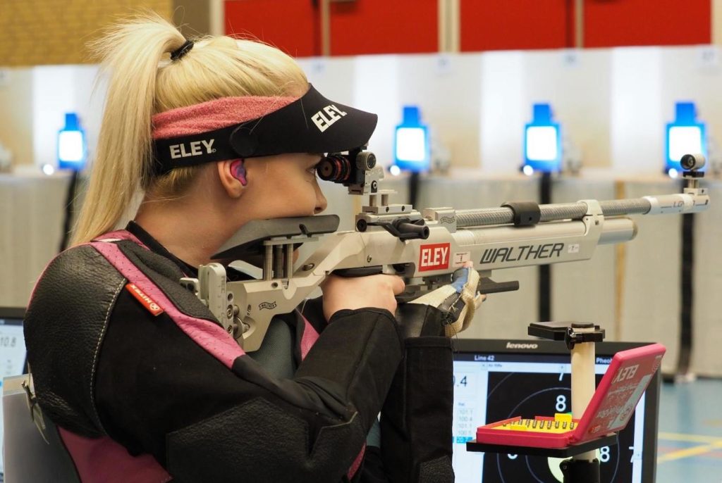 a young woman shooting an air rifle in ISSF Competition