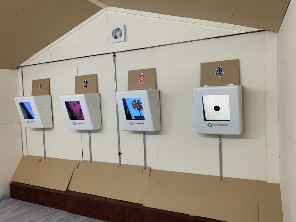 Four electronic targets mounted on the wall of an airgun shooting range