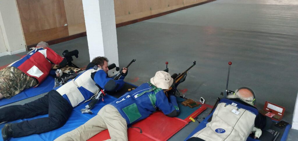 A group of target shooters on an indoor range.