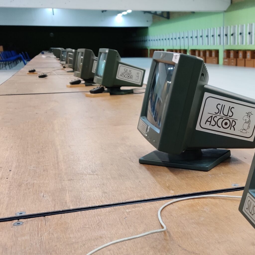 A row of computer monitors on a bench at the firing point of a 10metre airgun range